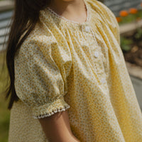 Elma Delphi Blouse in Haru Blossom Buttercup, featuring tiny yellow florals on buttery-yellow Japanese cotton, puff sleeves, shirred cuffs and picot lace trim.