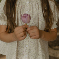 Elma Delphi Blouse in Haru Blossom Iris, featuring delicate purple florals on white Japanese-milled cotton, a shirred neckline, puff sleeves with elasticated cuffs and picot lace trim.