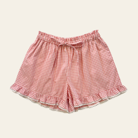 Elma Lilia Shorts in pink and white Sweet Pea Gingham, featuring an elasticated drawstring waistband, side pockets and ruffled hems with delicate white picot lace trim.