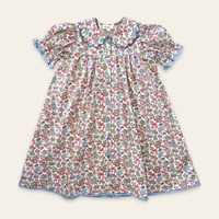 Elma Mae Dress in Liberty Nancy Ann floral cotton, featuring a scalloped collar with blue embroidery, blue buttons, puff sleeves and a gathered skirt.