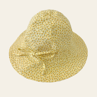 Elma Poppy Sunhat in Haru Blossom Buttercup, featuring tiny tonal blossoms on soft buttery-yellow Japanese cotton, an adjustable crown tie and under-chin tie with toggle.