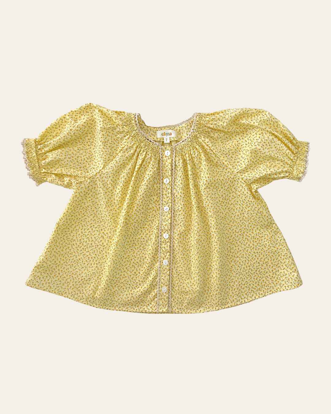 Elma Delphi Blouse in Haru Blossom Buttercup, featuring tiny yellow florals on buttery-yellow Japanese cotton, puff sleeves, shirred cuffs and picot lace trim.
