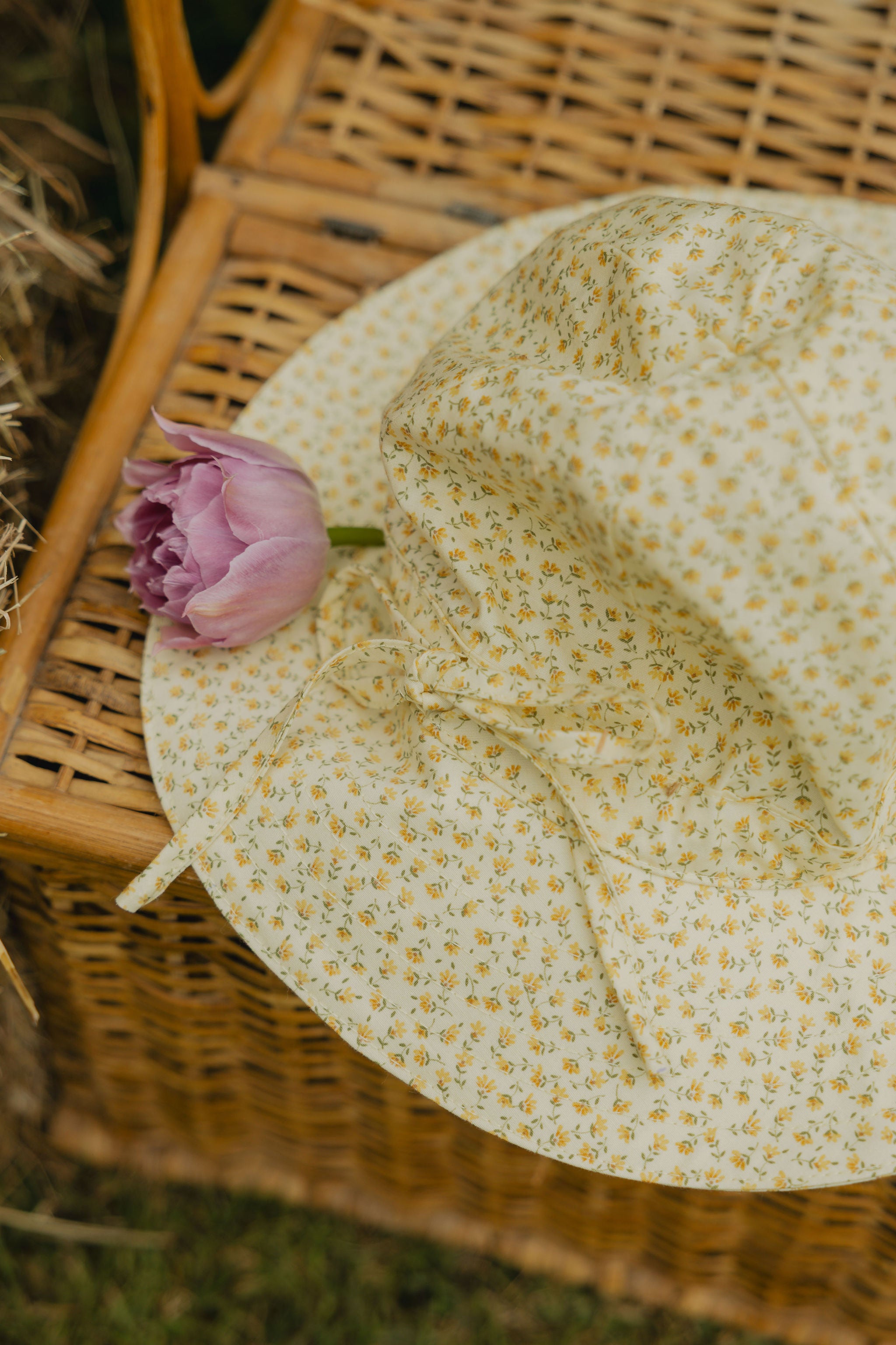 Elma Poppy Sunhat in Haru Blossom Buttercup, featuring tiny tonal blossoms on soft buttery-yellow Japanese cotton, an adjustable crown tie and under-chin tie with toggle.