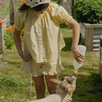 Elma Delphi Blouse in Haru Blossom Buttercup, featuring tiny yellow florals on buttery-yellow Japanese cotton, puff sleeves, shirred cuffs and picot lace trim.
