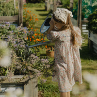 Elma Mae Dress in Liberty Nancy Ann floral cotton, featuring a scalloped collar with blue embroidery, blue buttons, puff sleeves and a gathered skirt.