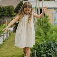Elma Colette Dress in Haru Blossom Iris, featuring delicate purple florals on Japanese-milled cotton, a Peter Pan collar, back ties and a gathered skirt.