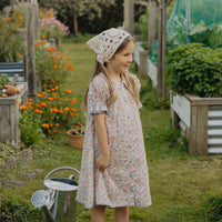 Elma Mae Dress in Liberty Nancy Ann floral cotton, featuring a scalloped collar with blue embroidery, blue buttons, puff sleeves and a gathered skirt.