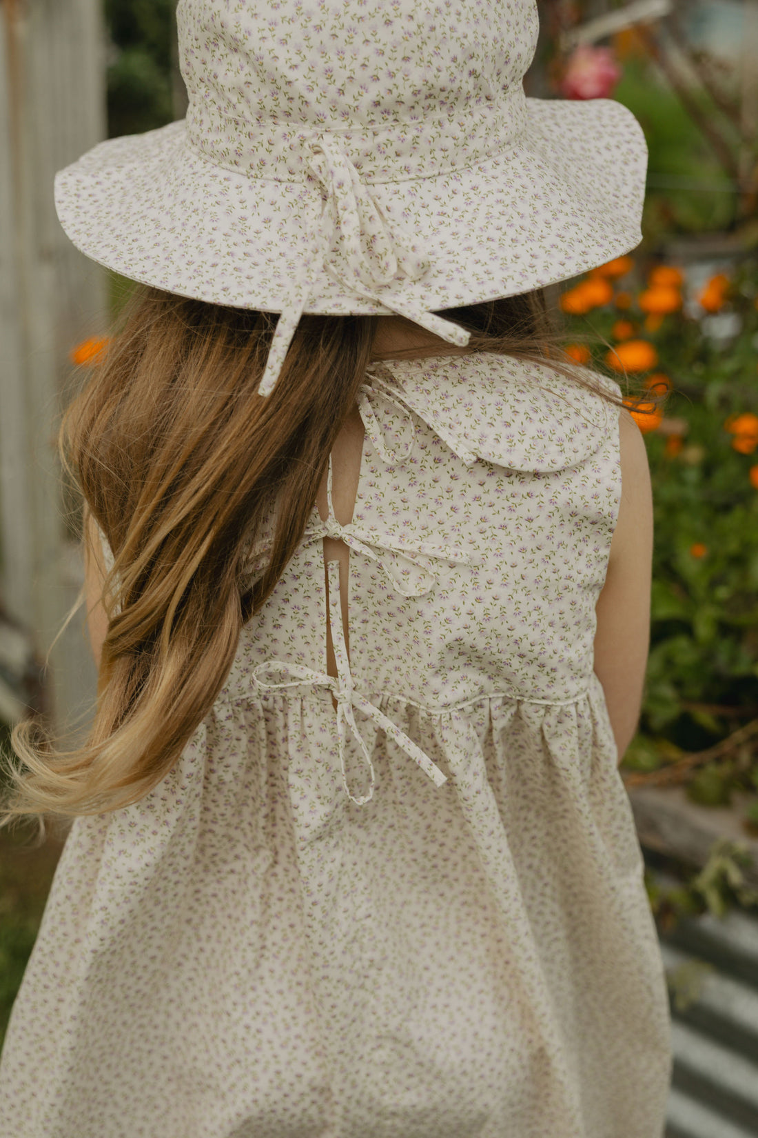 Elma Colette Dress in Haru Blossom Iris, featuring delicate purple florals on Japanese-milled cotton, a Peter Pan collar, back ties and a gathered skirt.