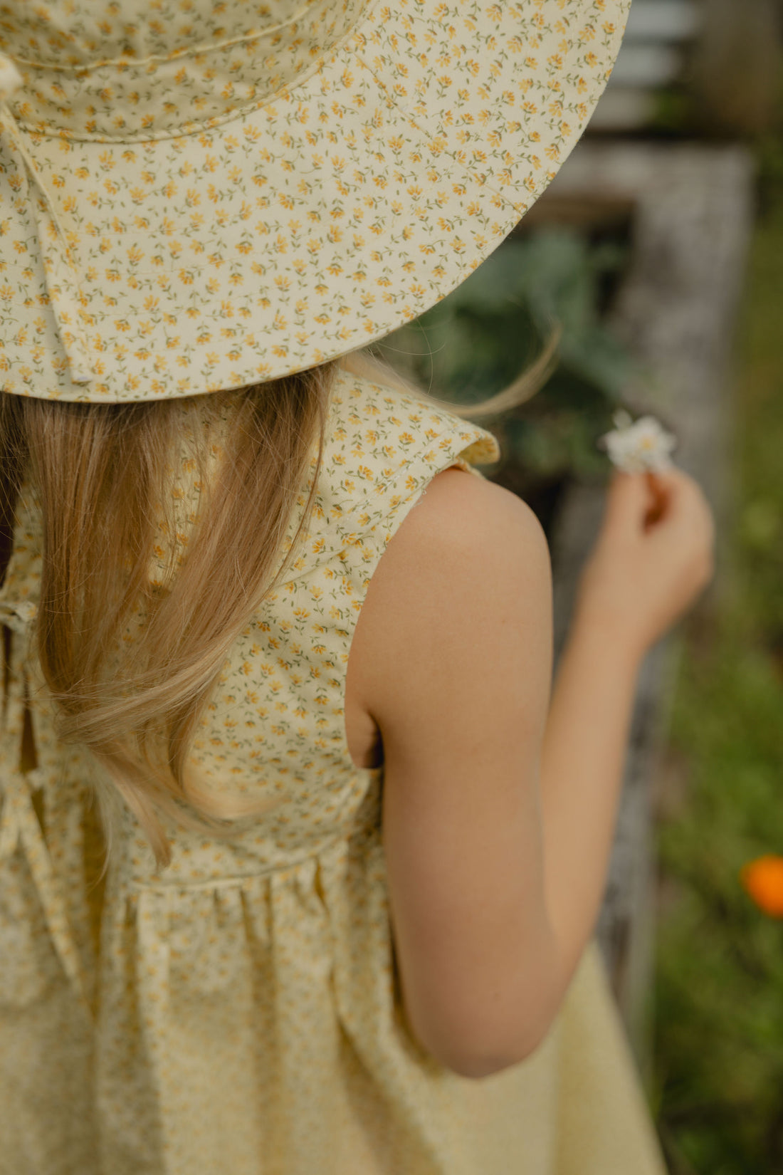 Elma Colette Dress in Japanese Floral, featuring tiny yellow flowers on a soft buttery-yellow cotton base, Peter Pan collar and gathered skirt.
