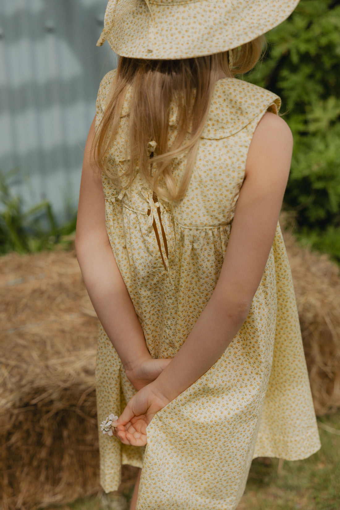 Elma Colette Dress in Japanese Floral, featuring tiny yellow flowers on a soft buttery-yellow cotton base, Peter Pan collar and gathered skirt.