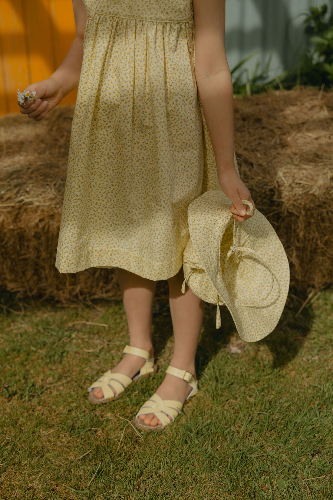 Elma Poppy Sunhat in Haru Blossom Buttercup, featuring tiny tonal blossoms on soft buttery-yellow Japanese cotton, an adjustable crown tie and under-chin tie with toggle.