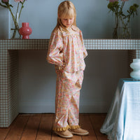 Girl wearing Lucie Pants in Liberty Morley Hill floral with embroidered lace trim and self-tie waist detail