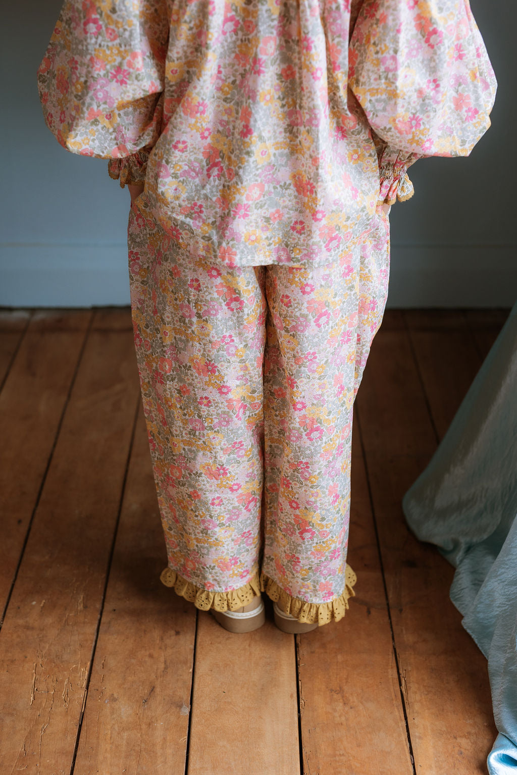 Girl wearing Lucie Pants in Liberty Morley Hill floral with embroidered lace trim and self-tie waist detail