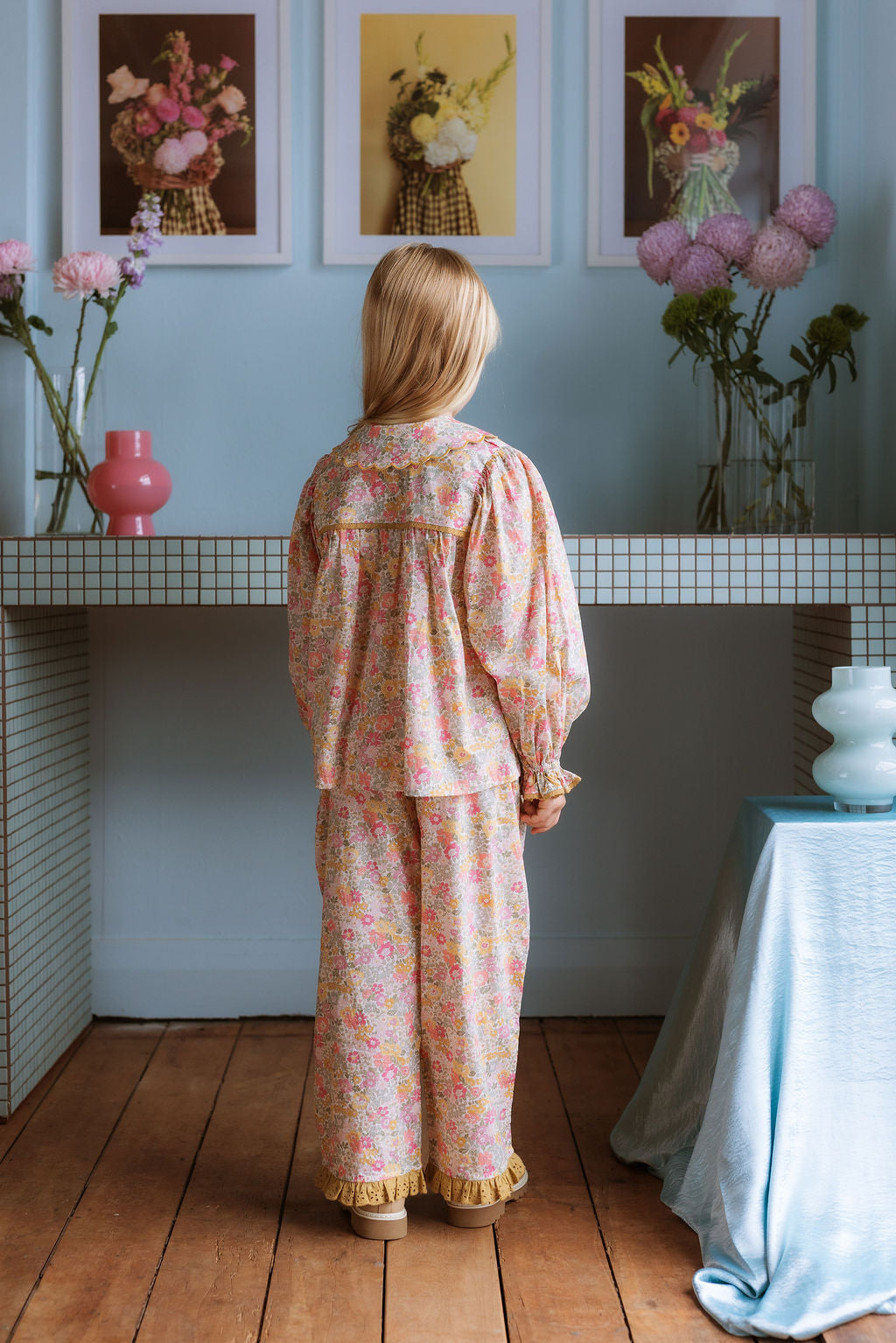 Girl wearing Lucie Pants in Liberty Morley Hill floral with embroidered lace trim and self-tie waist detail