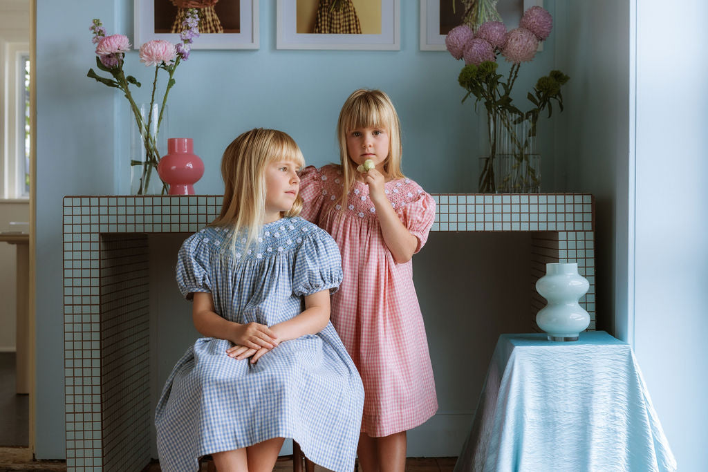 Gingham girls’ Celeste Dress, hand‑smocked and embroidered, and puff sleeves from Elma.