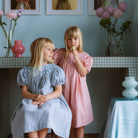 Gingham girls’ Celeste Dress, hand‑smocked and embroidered, and puff sleeves from Elma.