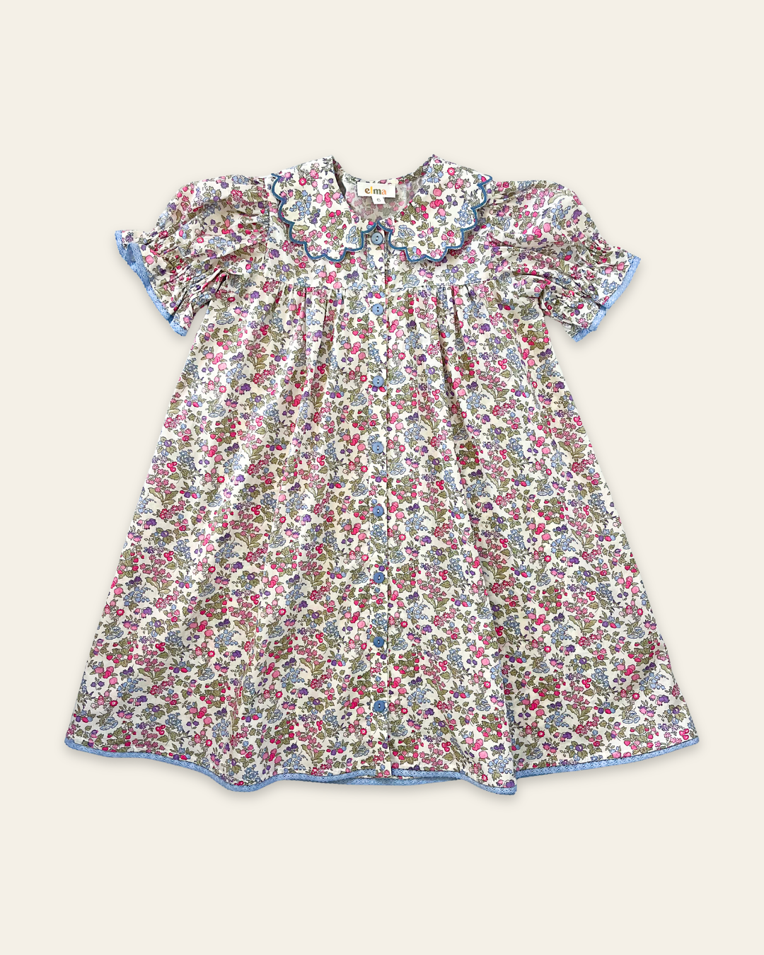 Elma Mae Dress in Liberty Nancy Ann floral cotton, featuring a scalloped collar with blue embroidery, blue buttons, puff sleeves and a gathered skirt.