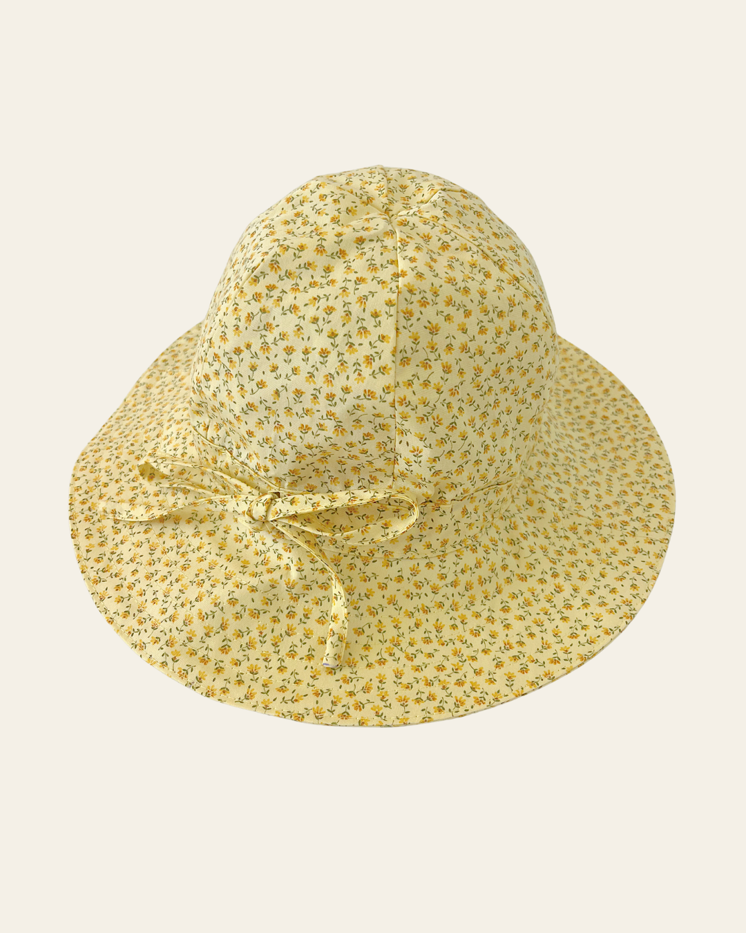 Elma Poppy Sunhat in Haru Blossom Buttercup, featuring tiny tonal blossoms on soft buttery-yellow Japanese cotton, an adjustable crown tie and under-chin tie with toggle.